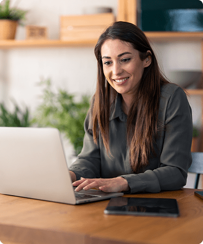 Smiling woman working on a laptop.